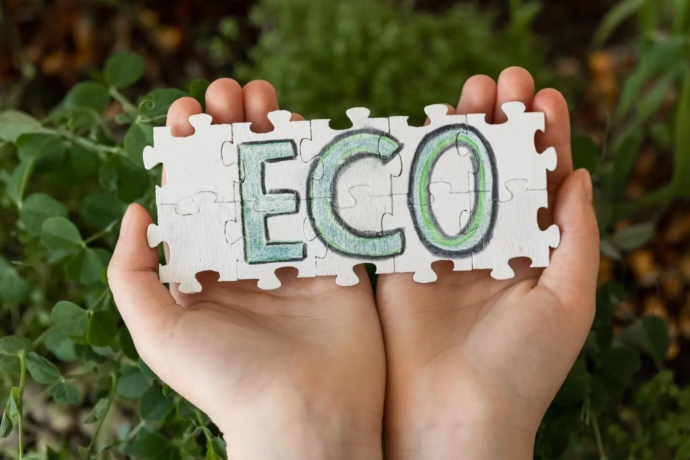 Puzzle mit der Aufschrift „eco“ in Händen vor dem Hintergrund von Microgreens.